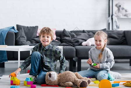 坐在地板上玩具的可爱快乐儿童在家图片