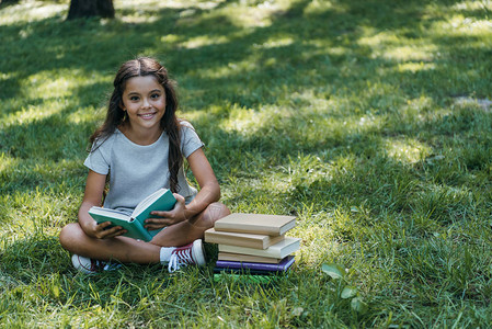 坐在草地上看书在公园里笑图片
