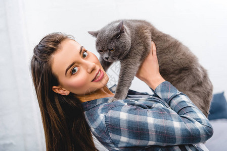 美丽的年轻美女拿着英国短发猫图片