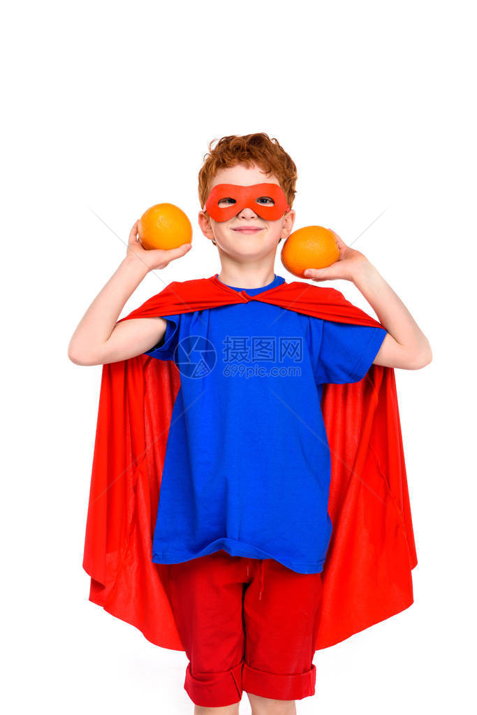 穿着超级英雄服装的快乐孩子拿着橙子笑图片