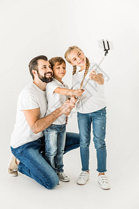 快乐的父亲和可爱的孩子可爱的小孩采取自拍用智能手图片