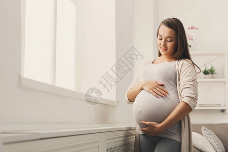 年轻的期待女士感觉她的婴儿推图片