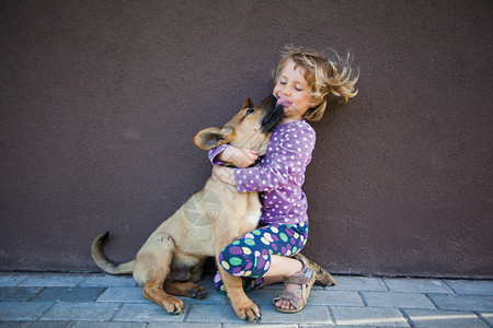 小女孩拥抱她的小狗图片