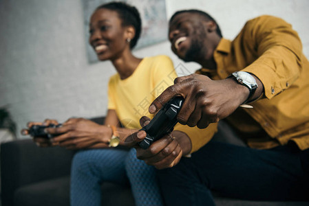 快乐的非洲年轻美国夫妇在家中一起玩游戏图片