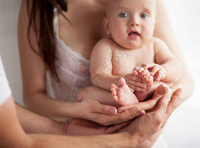 婴儿在母亲和父亲的手中父母双方都用手支图片