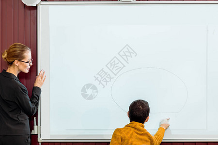 年轻老师用互动的白板看男学生习时使图片