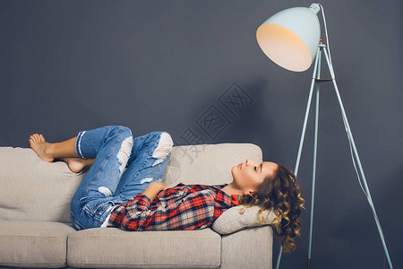 美丽的年轻女士躺在沙发图片
