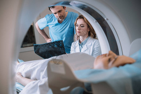 在Ct扫描仪诊断病人期间进行X射线诊断的深思医生有选择图片