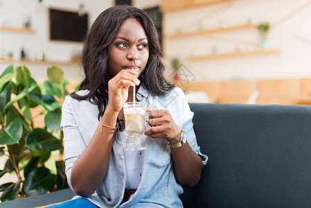 非洲女喝咖啡拿铁在咖啡图片
