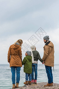一家人站在海边牵手的背影图片