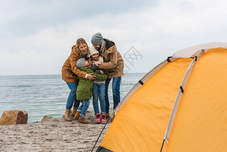 在海边露营的幸福拥抱家庭图片