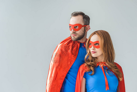 一对夫妇穿着超级英雄服装的情侣站在一起看背景图片