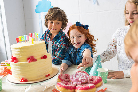 可爱的快乐的孩子在生日餐桌图片