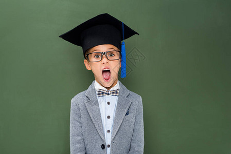 在黑板旁边戴着毕业帽子图片