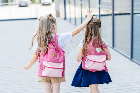 看着小女学生在街上向同学做图片