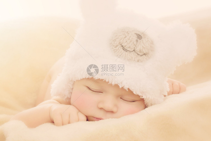 身着滑稽熊装帽子的新生婴儿男孩肖像图片