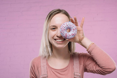 快乐的年轻姑娘用甜圈图片