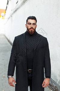 街上留着胡子穿着黑色外套的帅气时髦男人图片