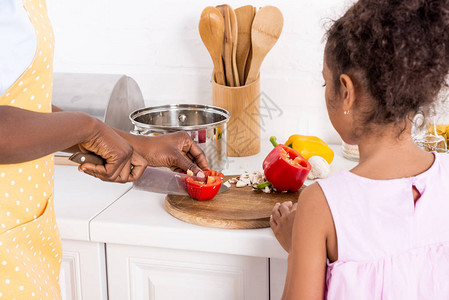 美籍非洲人母亲和女儿在厨房切胡椒图片