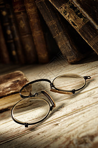 老桌子上的古董眼镜背景图片