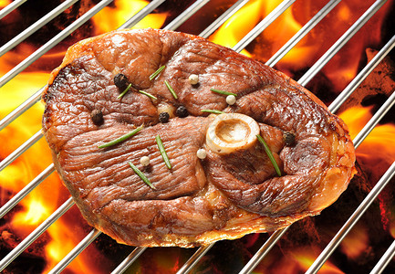 火焰烤架上的烤肉羊腿图片
