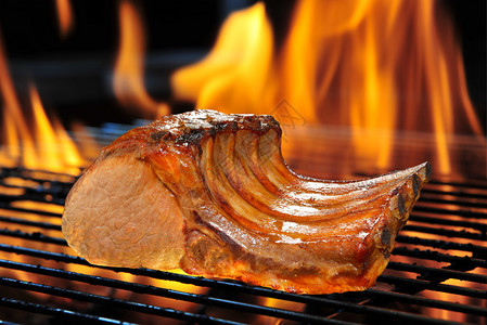 火焰状烤架上的烤猪排背景图片