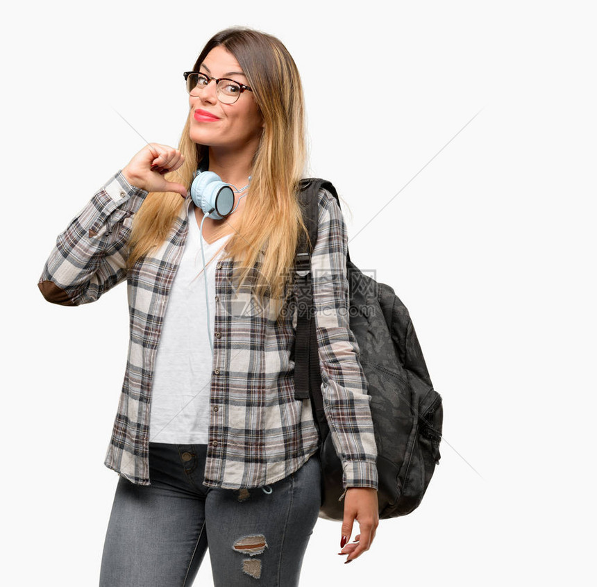 手持耳机和背包的年轻女学生带着耳机图片