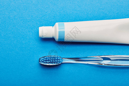 牙刷和牙膏按蓝色背景排列的牙刷和牙膏顶部视图片