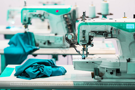 专业缝纫机和蓝色纺织品裁缝设备布业工厂生图片