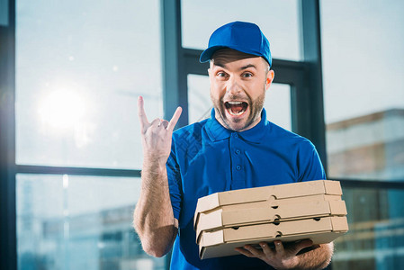 兴奋的快递员带着披萨在盒子中图片
