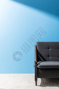 蓝色墙壁前舒适的灰色沙发背景图片