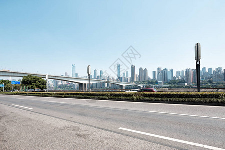 空旷的柏油路与蓝天下的重庆市容背景图片