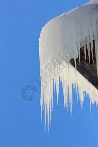 在屋顶的冰柱反对蓝天图片