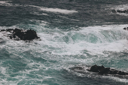 蓝色海洋波浪撞击岩石图片