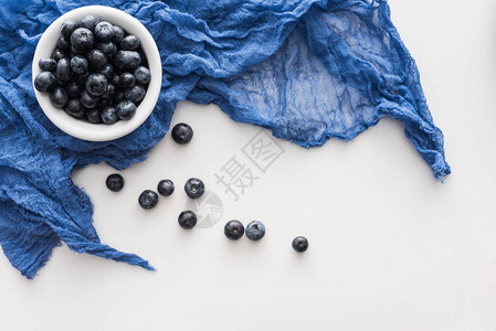 蓝布碗上甜蓝莓的顶视图背景图片