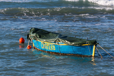 一艘用地布停泊在海湾的小木船背景图片