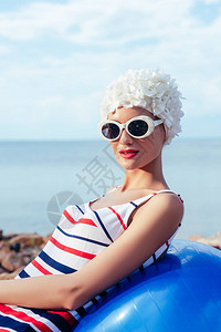 穿着条纹泳衣墨镜和白帽子的年轻女子在健图片
