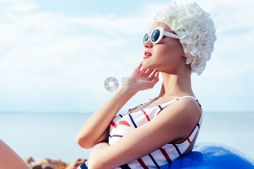 穿着条纹泳衣反太阳镜和白帽子的优雅女人在健图片