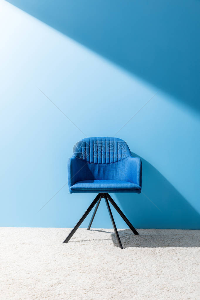 蓝色墙壁前舒适的蓝色椅子图片