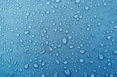 蓝色纤维防水织物上的水滴抽象背景图片