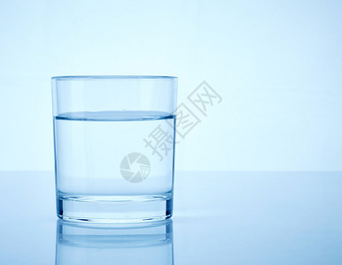 浅蓝色背景上的一杯水背景图片