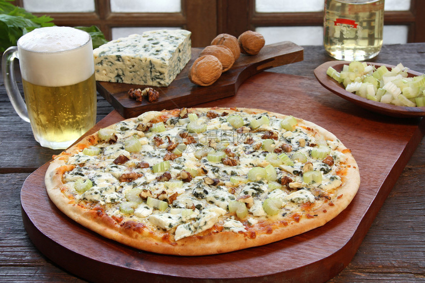 蓝纹奶酪披萨配一杯啤酒和一些配料图片