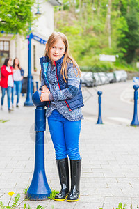 穿着蓝衣服和黑雨靴的7岁可爱小女孩外出肖像图片