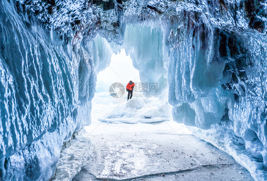 冬季风景冰冻的冰洞穴年轻摄影师独自站图片