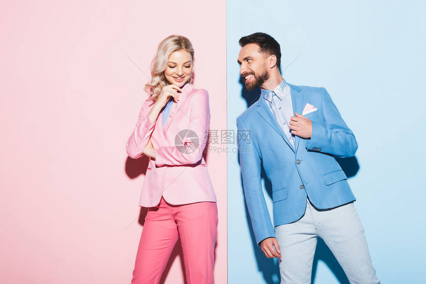 迷人的女人和微笑的男人看着她粉红色和蓝图片