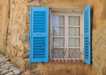 有蓝色百叶窗的房子的窗户图片