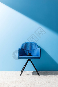 在蓝墙前的椅子上背景图片