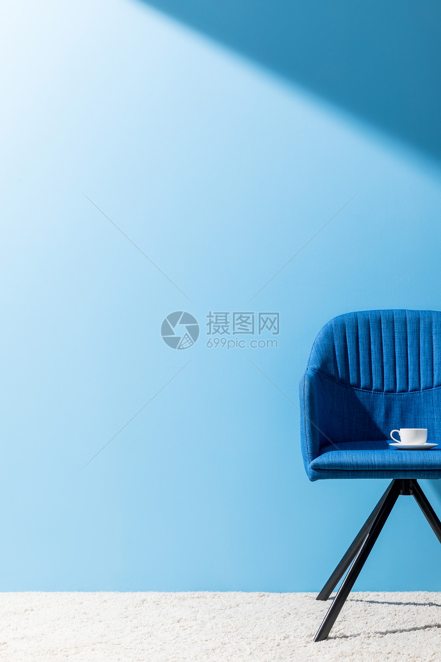 蓝色椅子蓝色墙前有咖图片