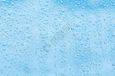 蓝色背景上的水滴玻璃上的雨滴图片