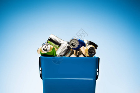 蓝色垃圾桶里的各种金属罐背景图片